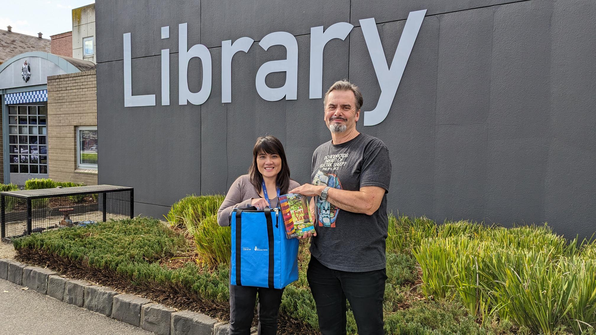 Home Library Service - staff holding bag outside library