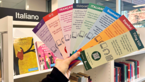 A photo showing an array of bookmarks in different community languages. The background is a library.